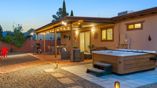 A covered patio area with a hot tub, outdoor seating, and a grill. - Mountain views! Big private yard with pool - heat optional with fee & spa! (Tucson)