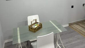 Ein Essbereich mit einem Glastisch, weißen Stühlen und einer kleinen Holzkiste auf dem Tisch.