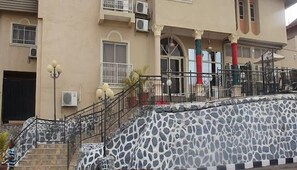 A building with a stone facade, a staircase, and a balcony with railings. - Royal Pavilion Hotel and Suites  (Abeokuta)