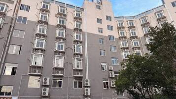 Un edificio de varios pisos con fachada simétrica, múltiples ventanas y unidades de aire acondicionado.