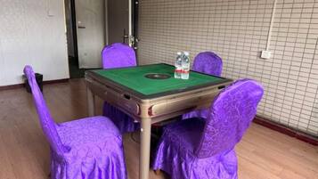 A room with a green felt table and chairs, two bottles of water, and a door to the left.