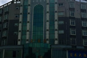 A multi-story building with a central arched window and multiple balconies.