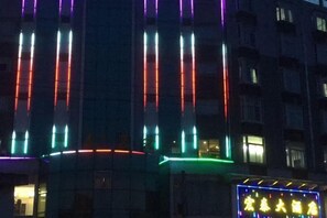 A building facade with vertical light strips and a neon sign. - Pingnan Xiangyue Hotel (Pingnan)