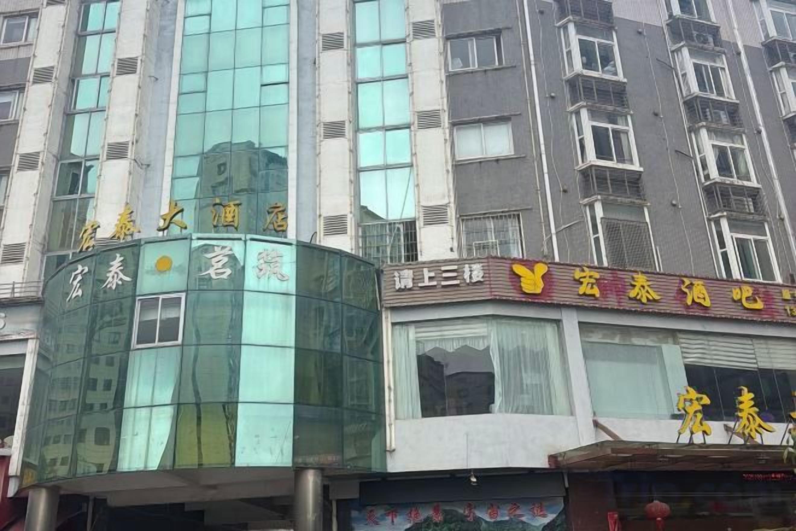 A multi-story building with a glass facade and signage indicating a hotel.