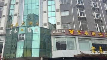A multi-story building with a glass facade and signage indicating a hotel.