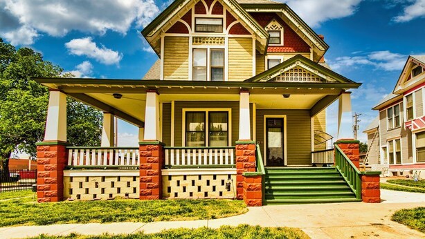 A two-story house with a porch, green steps, and a brick foundation. - Spacious 7-bedroom, 4 bathroom house with WiFi and new HVAC in wonderful Wichita (Wichita)
