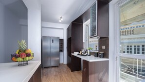 Una cocina moderna con un refrigerador de acero inoxidable, gabinetes de madera y un frutero en la encimera.