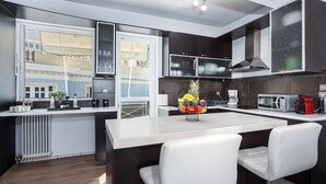 Una cocina moderna con una isla central, muebles oscuros y vistas al exterior.