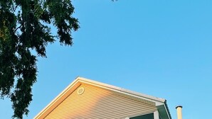 Une maison à deux étages avec un porche couvert et une cheminée.