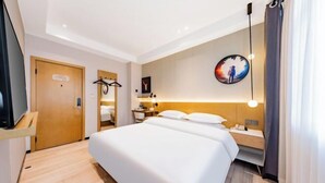 A hotel room with a bed, bedside table, TV, and a painting on the wall. - JIN YOTEL(South Second Ring & South Shiyangqiao Road, Hohhot) (Hohhot)