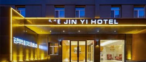 A hotel entrance with a prominent sign reading 'JINYI HOTEL' and a visible entrance door.