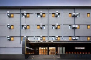 A modern hotel building with multiple floors, air conditioning units, and a prominent entrance with glass doors. - JIN YOTEL(South Second Ring & South Shiyangqiao Road, Hohhot) (Hohhot)