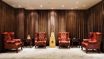 A room with four leather armchairs, a small table, and a decorative item in the center.