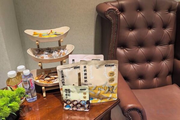 A dining table with food items, a chair, and a bottle of water. - JIN YOTEL(South Second Ring & South Shiyangqiao Road, Hohhot) (Hohhot)