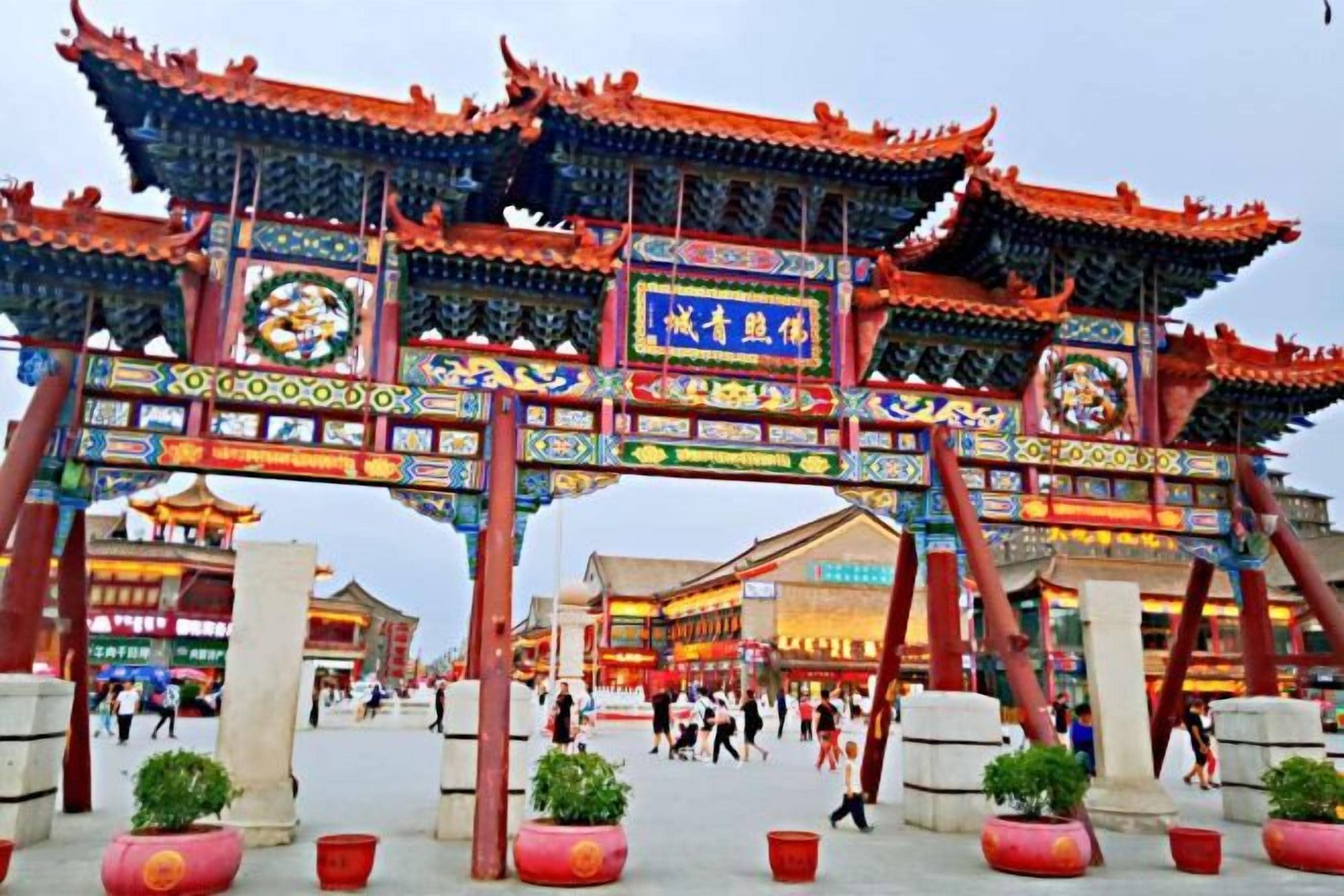 Une porte chinoise traditionnelle, ornée de motifs complexes et comportant plusieurs arcs.