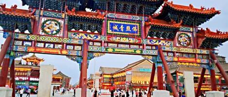 Une porte chinoise traditionnelle, ornée de motifs complexes et comportant plusieurs arcs.