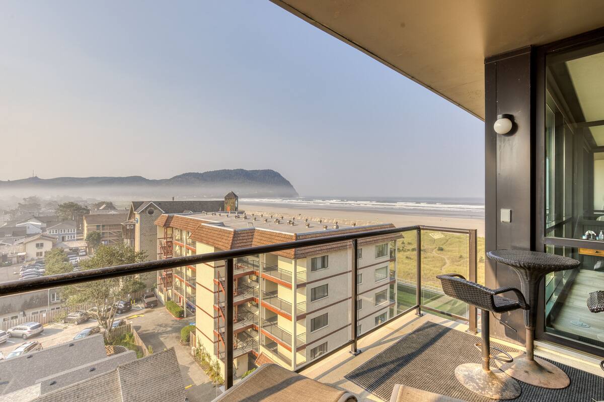 Un balcone con vista sulla spiaggia e su un edificio con diversi piani e balconi.