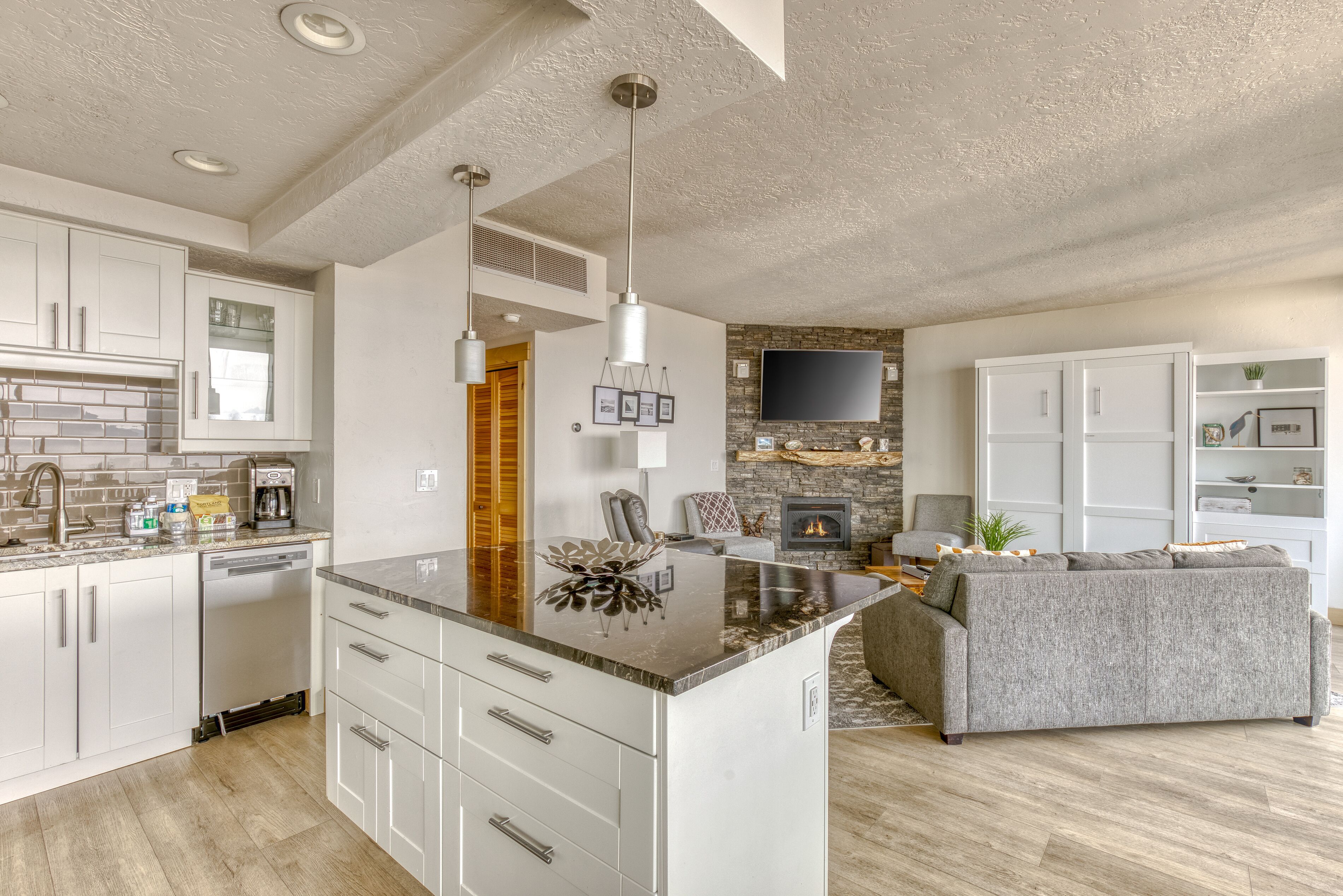 Une cuisine moderne avec des meubles blancs, un îlot central et une cuisinière intégrée.