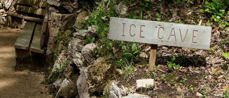 Señal para una cueva de hielo, con un banco de madera cerca.