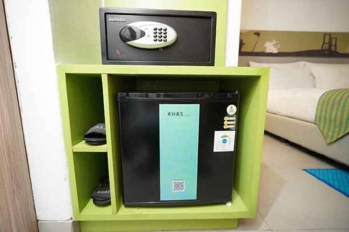 A green storage unit with a black electronic device on top and a black box labeled 'KHAS' inside.