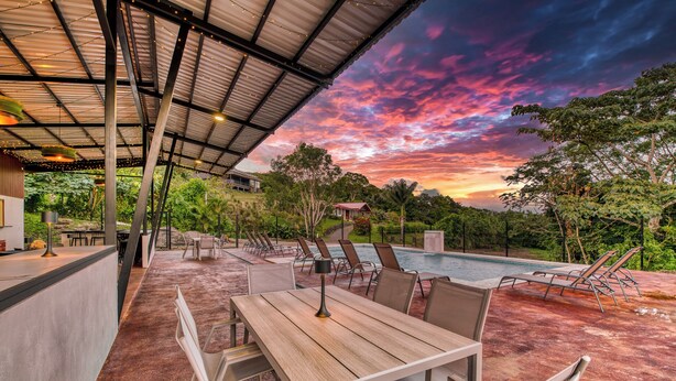 A covered outdoor area with a pool, lounge chairs, and a dining table. - Bonita Apt. Amazing 2nd floor Apt - Views Galore! (Tilarán)
