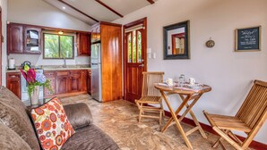 A kitchen with wooden cabinets, a refrigerator, and a window with a view of greenery. - Bonita Apt. Amazing 2nd floor Apt - Views Galore! (Tilarán)