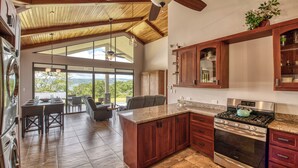 Una cocina con una isla grande, horno empotrado y comedor con vistas.