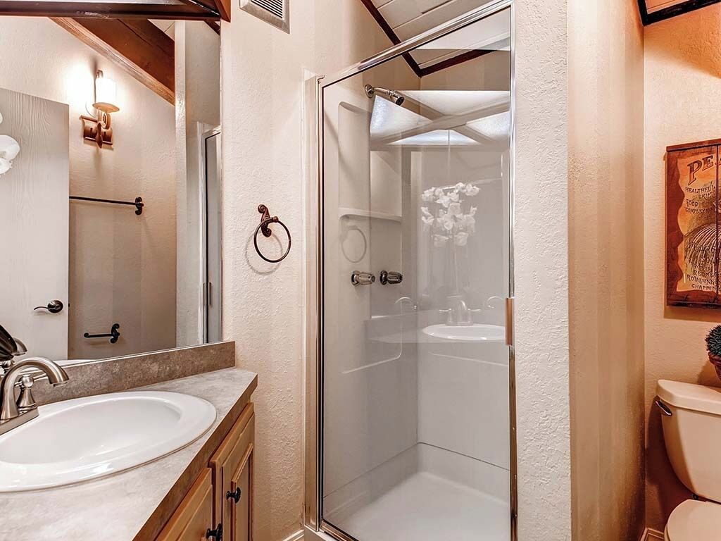 Une salle de bain moderne avec une douche à parois de verre, un lavabo et des toilettes.