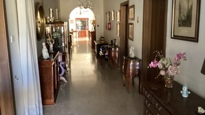 A hallway with a chandelier, wooden furniture, and a vase with flowers. - Triple bed & breakfast with AC and WiFi with pool and indoor pool (Naxxar)