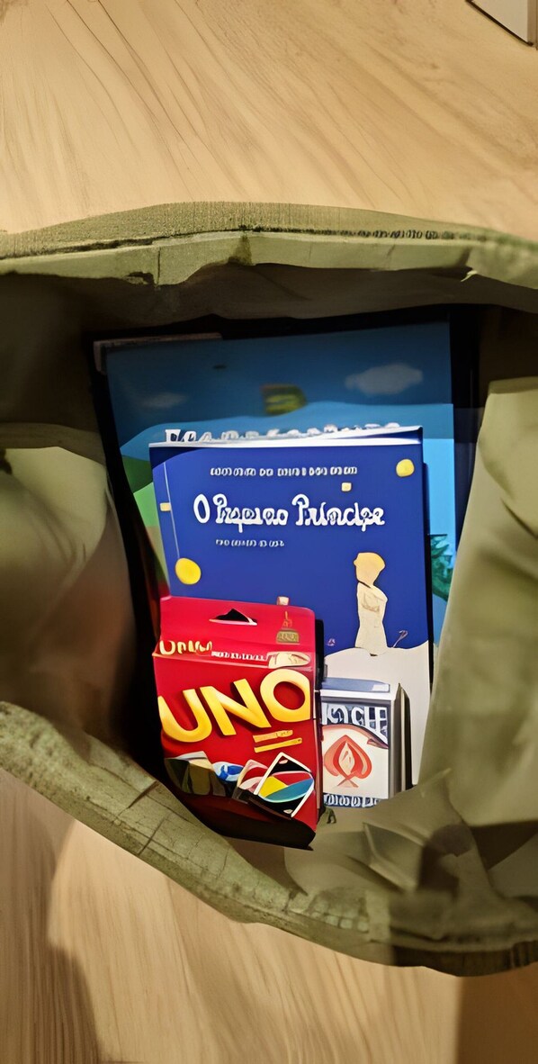 A bag containing a book titled 'Oro Posse Prince', a UNO game, and a pack of cigarettes.