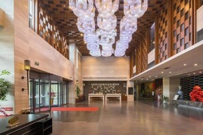 A spacious lobby with a modern chandelier, a reception desk, and a seating area. - Winterless Hotel Wuxi (Wuxi)