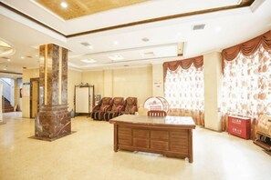 A lobby with a reception desk, seating area, and a large pillar. - Runfeng Hotel (Meishan)