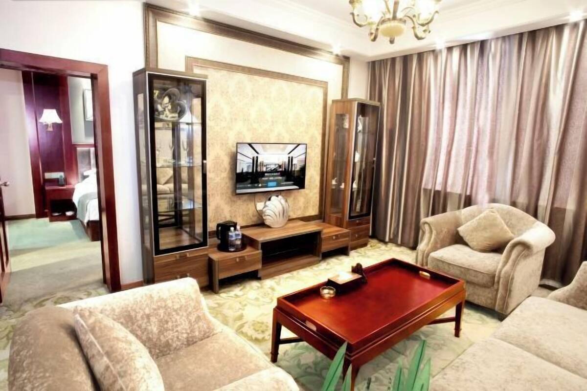 A living room with a billiards table, a television, and a sofa.