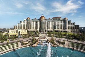 A large hotel with a central fountain, multiple balconies, and a well-maintained garden. - Universal's Helios Grand Hotel, a Loews Hotel (Orlando)