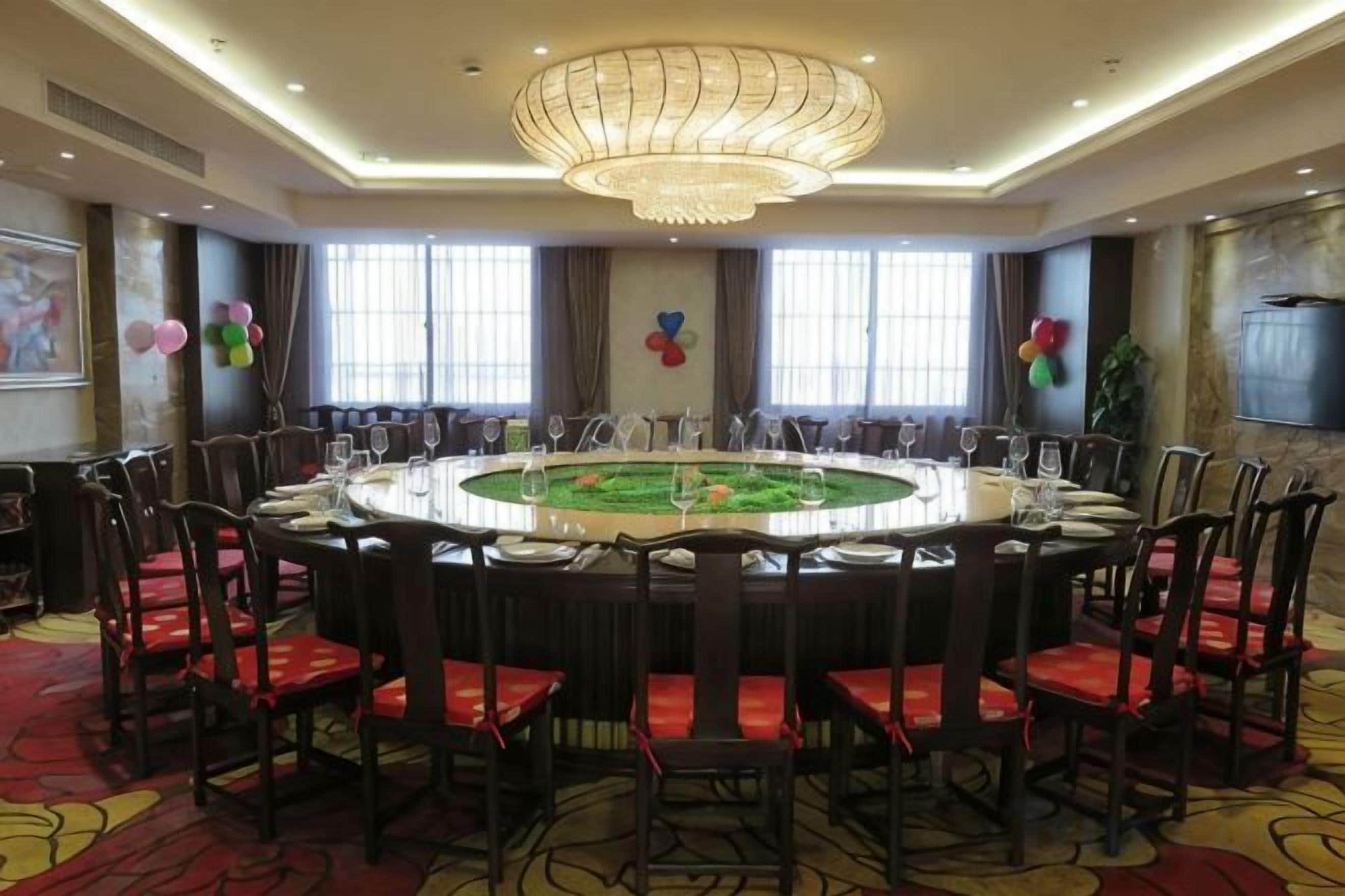 A conference room with a round table, chairs, and a chandelier.