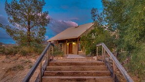 A wooden staircase leading to a lodge with a sloped roof, surrounded by trees and a clear sky. - Hot Tub-Pool-Amazing Views! Sleeps 18! (Tucson)