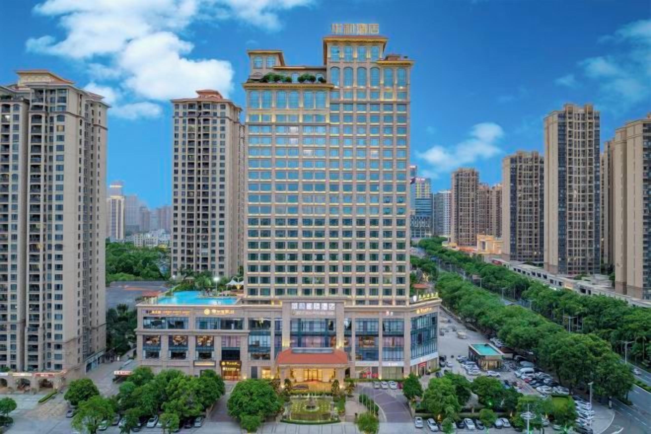 A high-rise hotel with multiple floors, a central courtyard, and surrounding greenery.