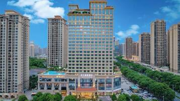 A high-rise hotel with multiple floors, a central courtyard, and surrounding greenery.