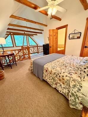 Un dormitorio con cama, escritorio, silla y un amplio ventanal.