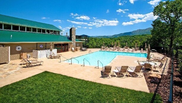 A pool area with lounge chairs and a building with a green roof. - Cabin with wonderful mountain views, 2 BR/2 BA, sleeps 6 (Townsend)