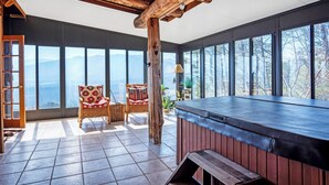 A spacious room with large windows offering mountain views, a wooden ceiling, and a bar area. - Authentic log cabin with a spectacular view !  Enjoy the seclusion and sunsets (Townsend)