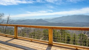 A wooden deck with a metal railing overlooking a mountainous landscape. - Authentic log cabin with a spectacular view !  Enjoy the seclusion and sunsets (Townsend)