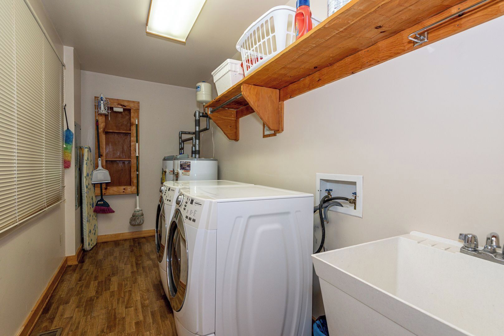 A laundry room with a washing machine, dryer, and a shelf above the dryer.