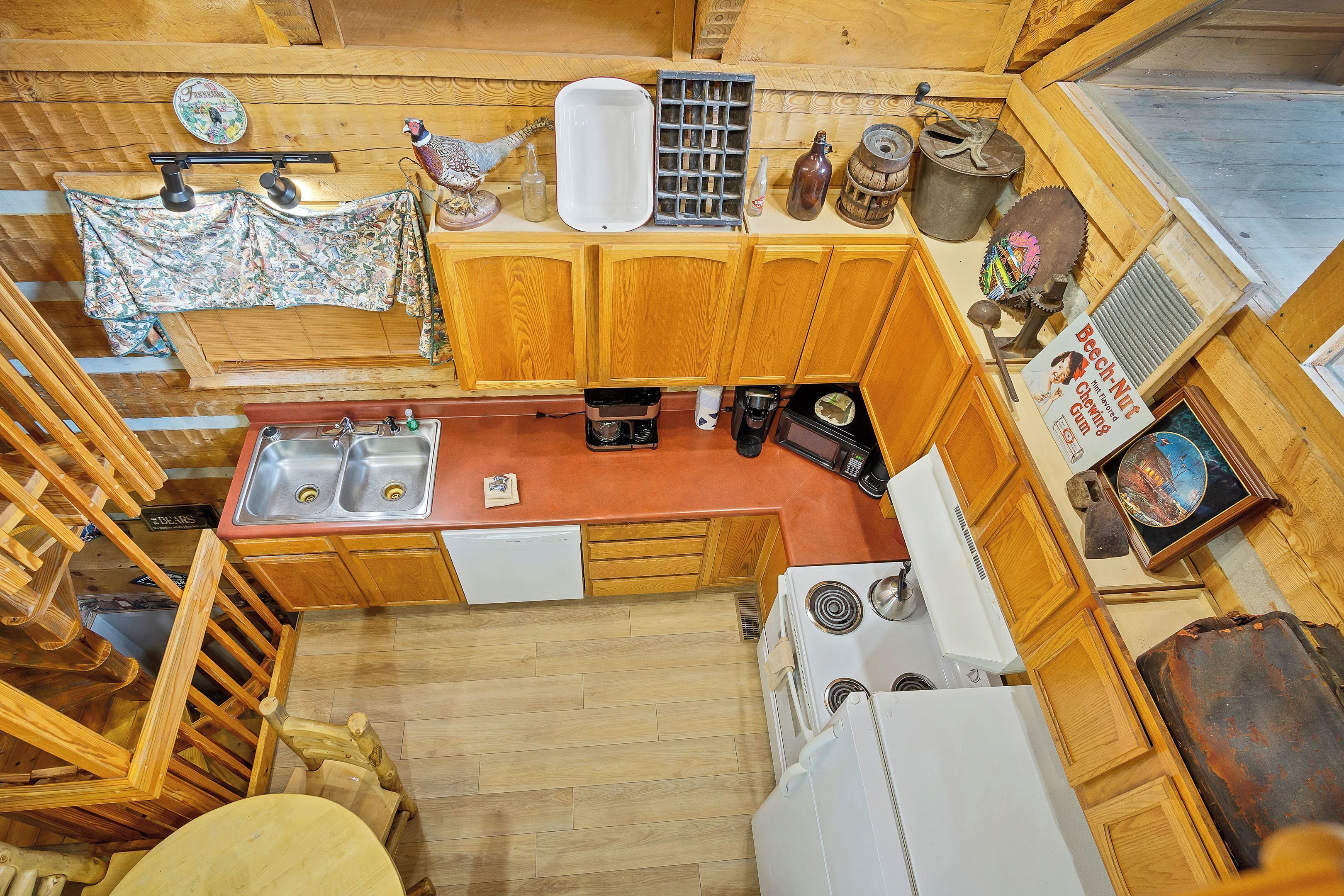 A compact kitchen with wooden cabinets, a sink, a stove, and a dining area with a table and chairs.