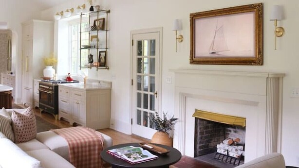 Una sala de estar con chimenea, un sofá, una mesa de centro y una araña.