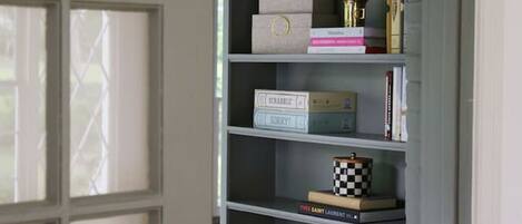 A grey built-in shelving unit with multiple shelves, some containing books and decorative items.