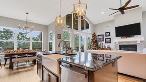 A spacious kitchen with a large island, modern appliances, and a ceiling fan.