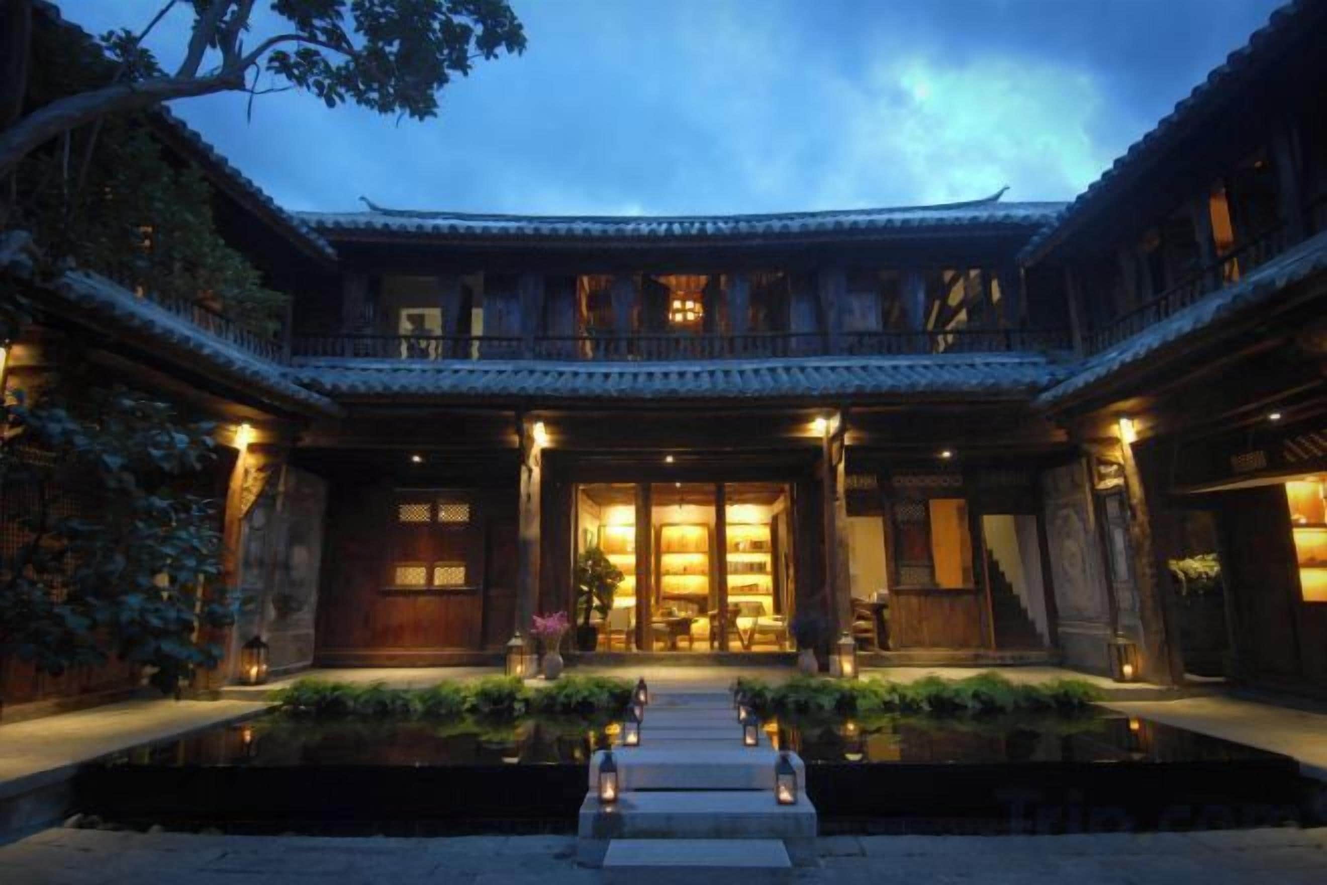 Un edificio tradicional con un patio, una fuente de agua y una entrada bien iluminada.