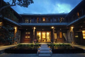 Un edificio tradicional con un patio, una fuente de agua y una entrada bien iluminada.
