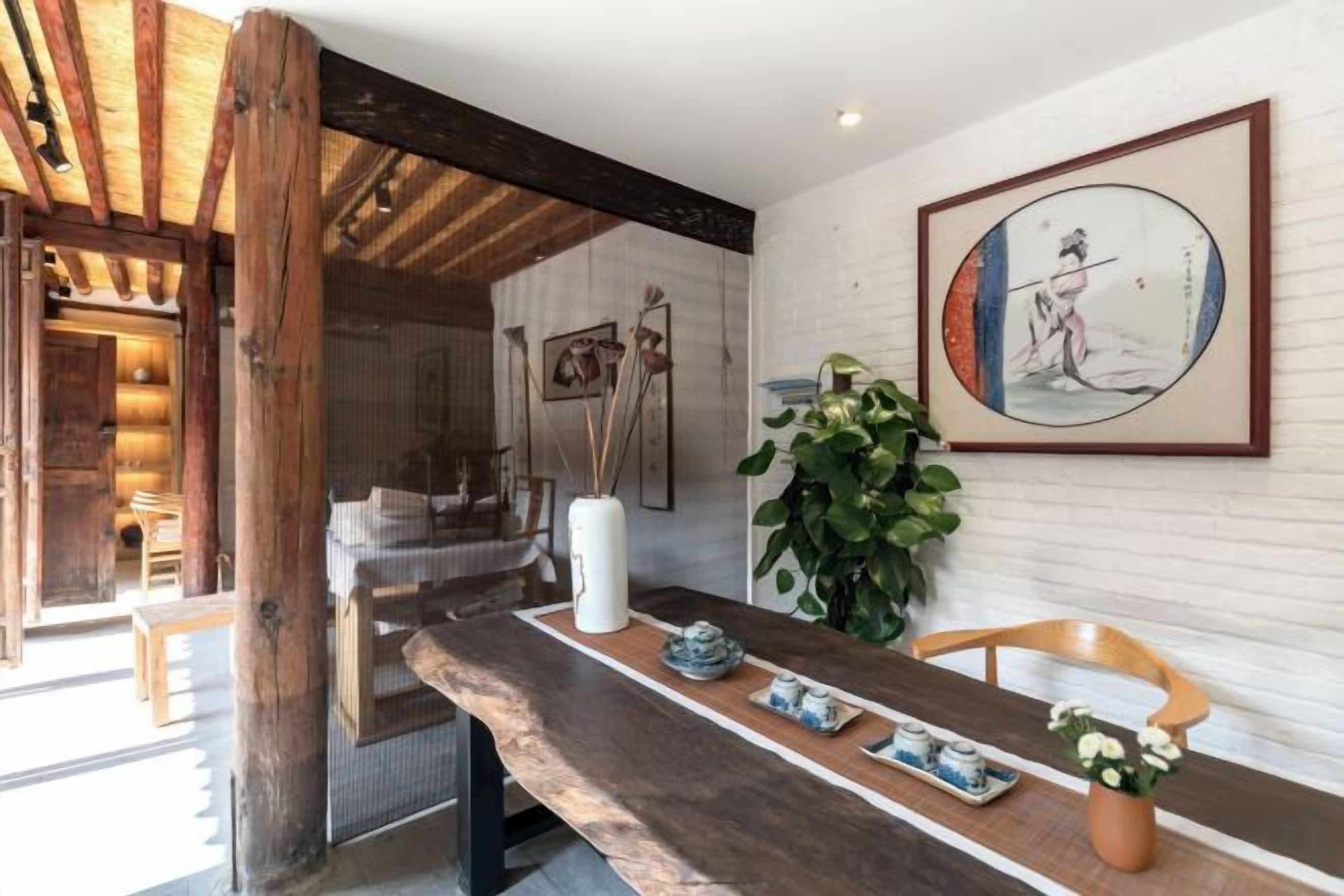 Ein Holzbüro mit einer Vase, einer Topfpflanze und einem gerahmten Bild an der Wand.